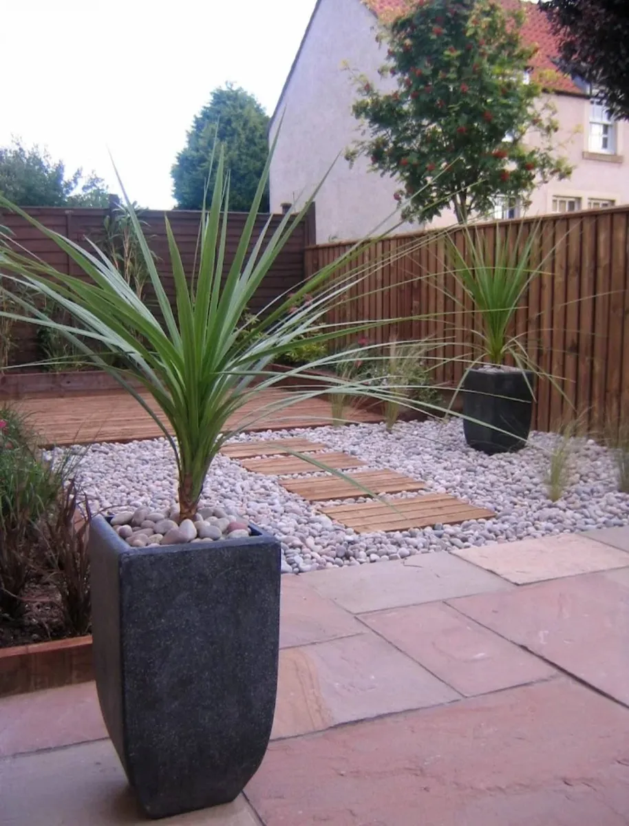 Interlocking stone flag paving pathway lined with decorative gravel borders